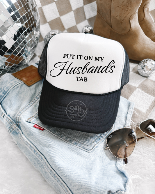 Put it on my husband's tab Trucker Hat